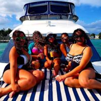 A group of women sitting on the bow of this Miami boat charter.