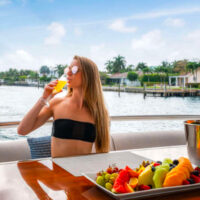 Guest sips a mimosa aboard our Miami boat charter.